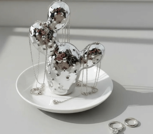 Porta-jóias mini cacto prata em cerâmica organizando anéis e colares em prato decorativo