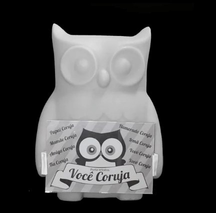 Imagem da luminária porta-retrato Você Coruja branca com LED interno, ambientada em mesa decorativa, destacando a exibição de foto e iluminação suave para salas e espaços aconchegantes.