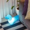 Luminária Cachorro Billy azul LED em sala decorada ao lado do sofá com iluminação ambiente suave